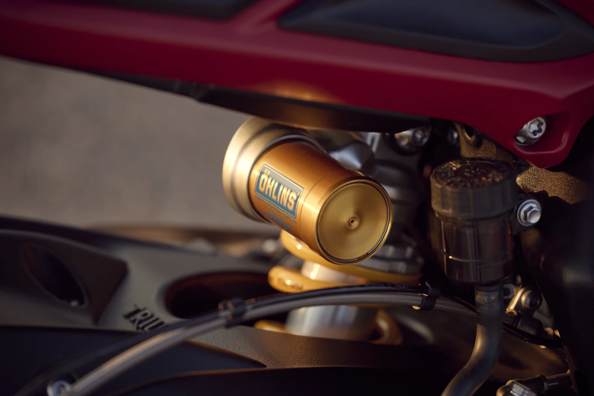 Monoamortiguador Öhlins STX40 dorado con depósito piggyback montado en el chasis de la Street Triple 765 RX