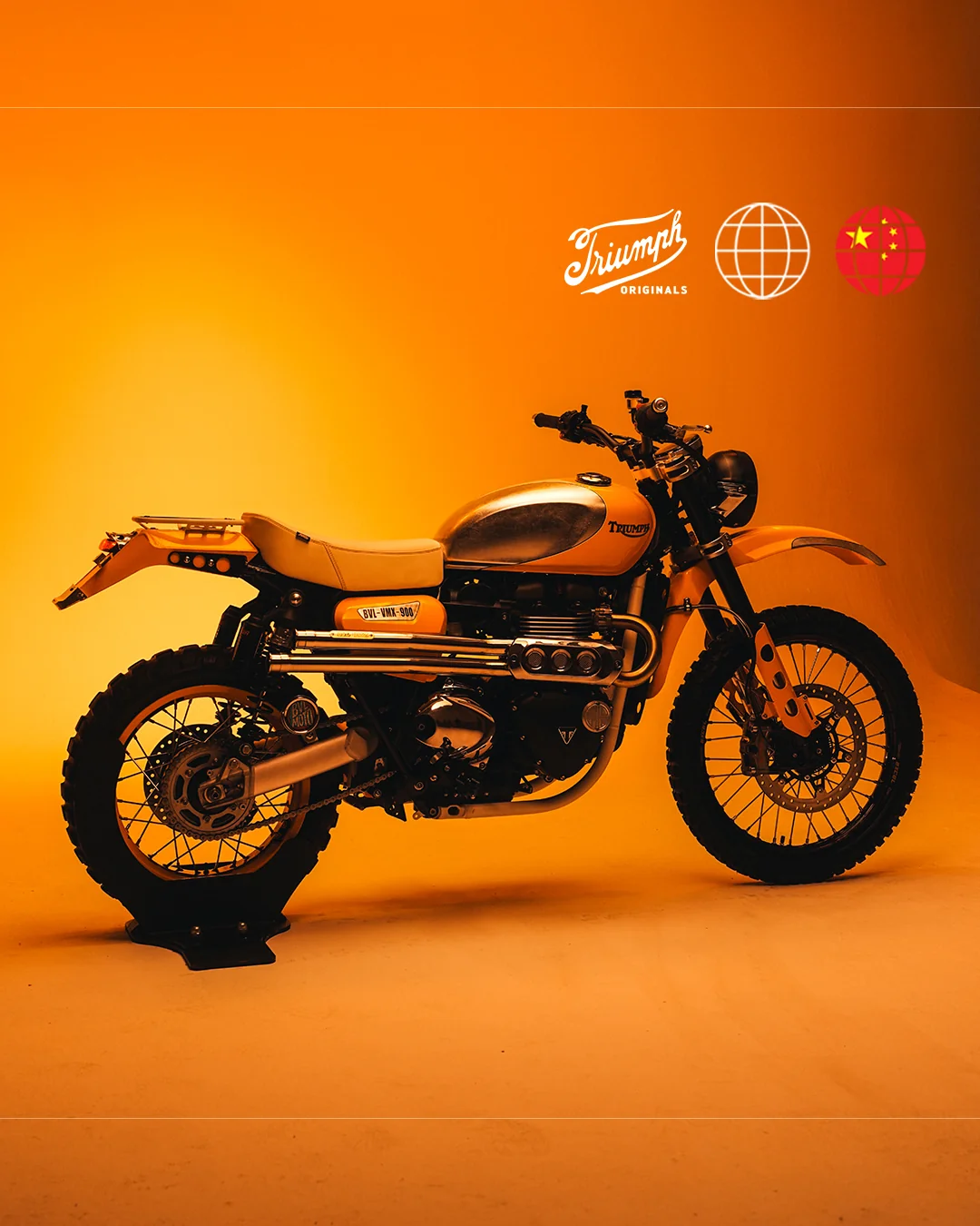 BVL-VMX-900 de BVL Garage: Scrambler 900 con depósito plateado y guardabarros amarillos sobre fondo naranja