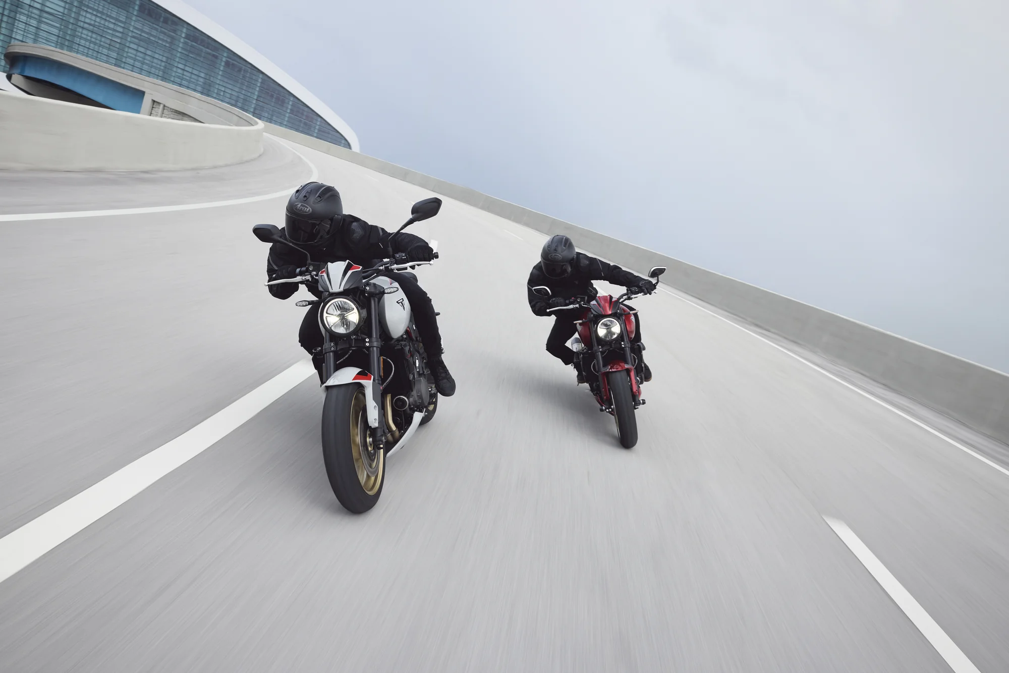 Dos pilotos conduciendo motocicletas Triumph Trident 800 en una vía urbana