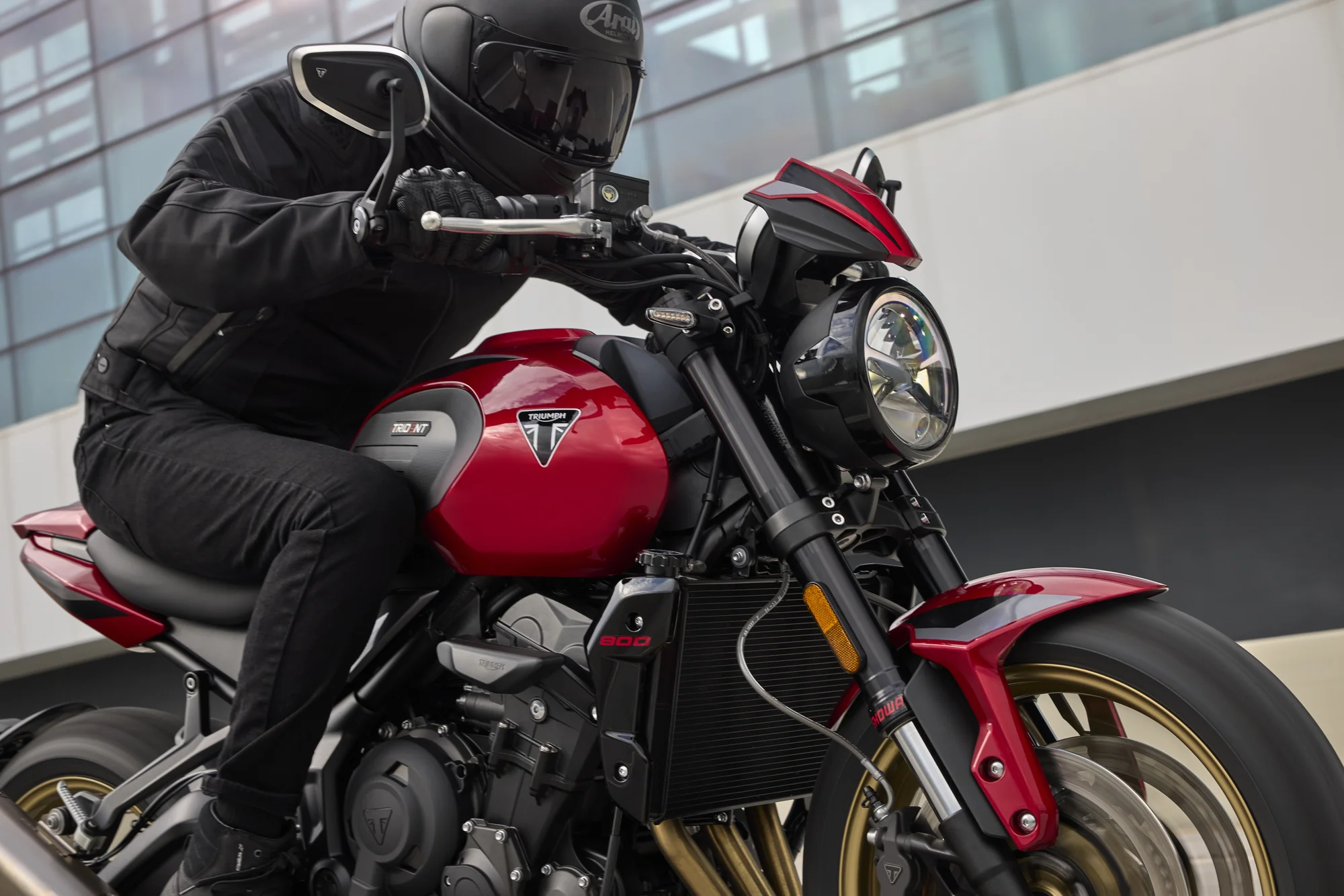 Vista delantera de la Triumph Trident 800 roja con un piloto sobre la motocicleta